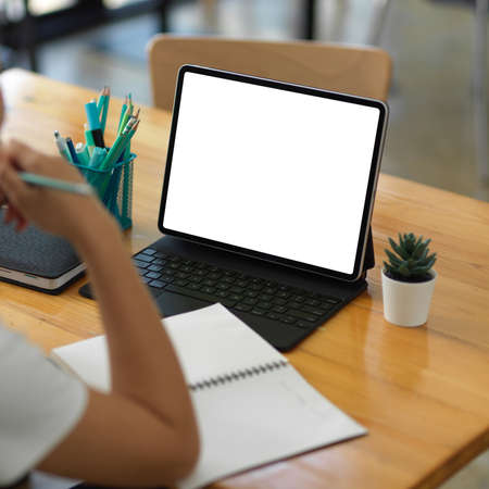 Cropped shot of student online studying with digital tablet and stationery on the table in living...