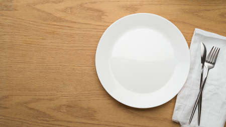 Table Setting Background, mock up ceramic plate, fork and table knife on white napkin, top view, empty ceramic dishの写真素材