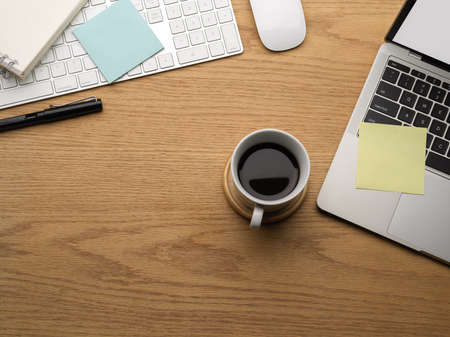 Top view of wooden table with copy space, laptop coffee cup and stationery, mock up creative scene