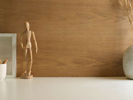 Minimal workspace with wooden figure, other decorations and copy space with wooden wall backgroundの写真素材