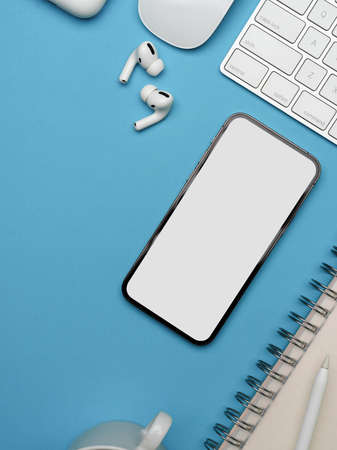 Cropped shot of creative flat lay workspace with smartphone, earphone, supplies and copy space on...