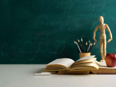 Cropped shot of school elements on white table with copy space and chalkboard wall backgroundの写真素材