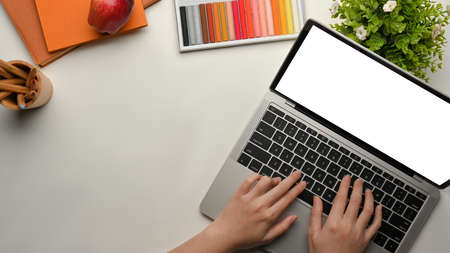 Top view of female hands working with laptop on workspace with paint tools and copy space, clipping pathの写真素材