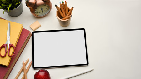 Top view of study table with digital tablet, books and stationery, clipping path, school elements