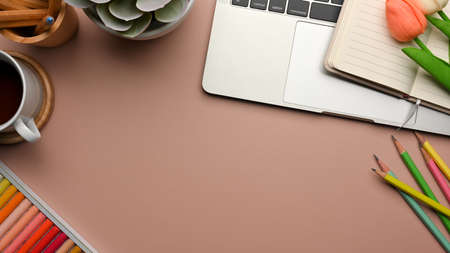 Pink creative flat lay workspace with stationery, laptop, paint tools, decorations, copy space, top viewの写真素材