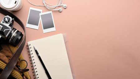 Top view of pink table with notebook, pen, camera, photo frame, bag and copy space, mock up scene