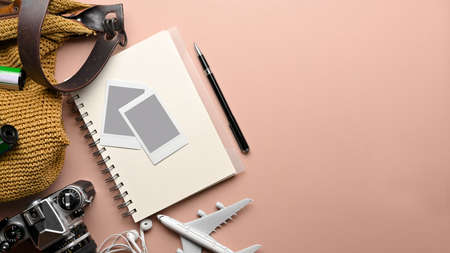 Travel concept creative mock up scene with notebook, camera, photo frame, bag and airplane model on pink backgroundの写真素材