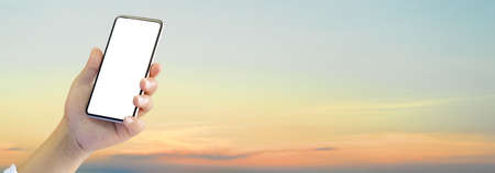 Male hand holding smartphone and showing mock up screen to camera in beautiful sunset sky background...