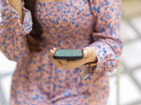 Close up view of female using smartphone while waiting coffee in cafeの写真素材