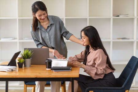 Portraits of two young businesswoman working on their work together in comfortable office roomの写真素材