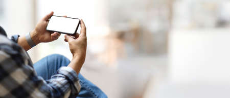 Cropped shot of businessman using horizontal smartphone include clipping path screen in blurred background with copy spaceの写真素材