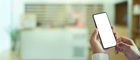 Male hands using smartphone include clipping path in blurred office background with copy spaceの写真素材