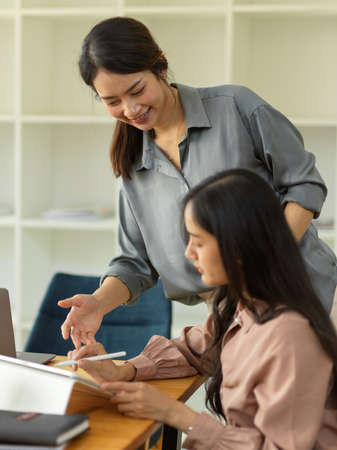 Cropped shot of two businesswoman discussing their work while origin together in meeting roomの写真素材