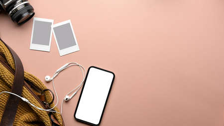 Top view of pink table with copy space, smartphone, photo card frame, camera, bag and earphone, clipping pathの写真素材