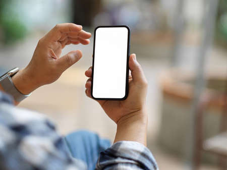 Close up view of businessman using smartphone and showing mock up screen to camera, clipping pathの写真素材