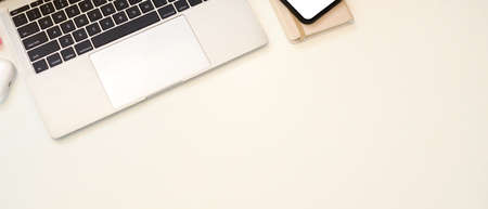 Top view of creative flat lay workspace with laptop, smartphone and copy space on white table
