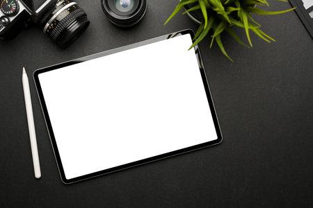 Top view of dark creative workspace with digital tablet include clipping path and camera on black tableの写真素材