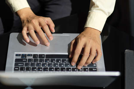 Cropped shot of young businessman typing laptop computer while working on his projectの写真素材