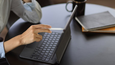 Cropped shot of young female working with mock up digital tablet in office roomの写真素材