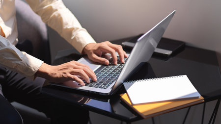 Side view of businessman hands typing on laptop keyboard on portable workspaceの写真素材