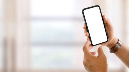 Close up view of male hands showing mock up smartphone screen to camera in blurred background, clipping pathの写真素材