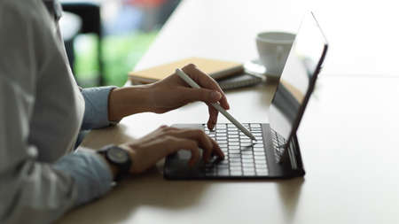 Cropped shot of young female working with digital tablet in office roomの写真素材