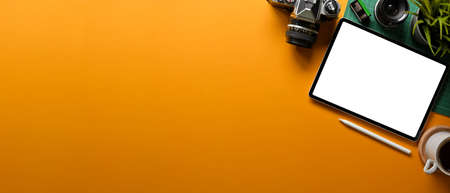Yellow creative flat lay workspace with digital tablet, camera, lens, plan pot and copy space, clipping pathの写真素材