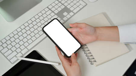 Top view of female hands using smartphone include clipping path screen on computer deskの写真素材