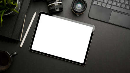 Dark creative flat lay with digital tablet, camera, stationery and accessories, top view, clipping pathの写真素材