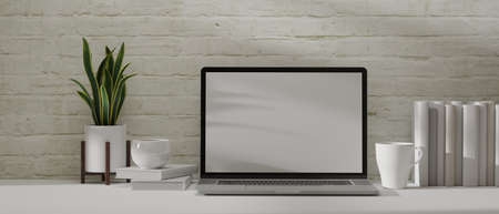 3D rendering, home office desk with laptop, books, mug, cup and plant pot white table with brick wall background, 3D illustrationの写真素材