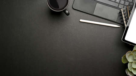 Dark creative mock up scene with tablet, accessories, mug and copy space, top view