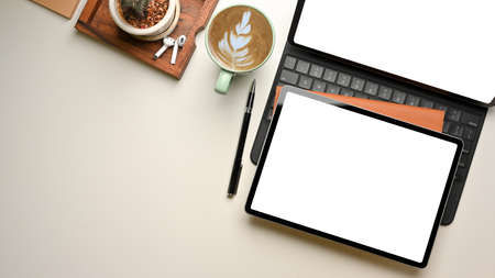 Overhead shot of workspace with two digital tablet, coffee cup, stationery and copy space, clipping pathの写真素材