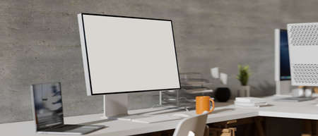 Side view of comfortable office desk with computer monitor, laptop and office supplies on the table, 3D rendering, 3D illustrationの写真素材