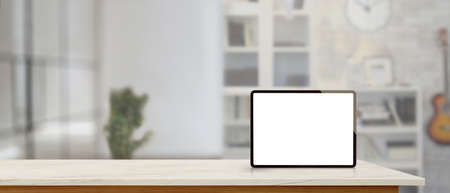Mock up digital tablet on marble counter with copy space in blurred living room backgroundの写真素材