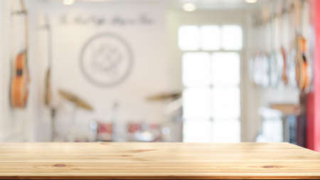Wooden table with copy space and blurred background with music instruments in the back, empty tableの写真素材