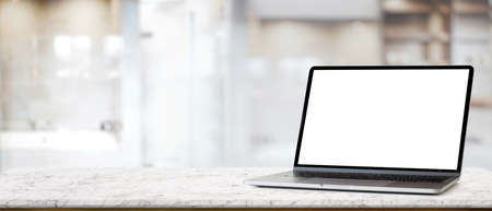 Close up view of marble desk with mock up laptop and copy space in blurred background, clipping pathの写真素材