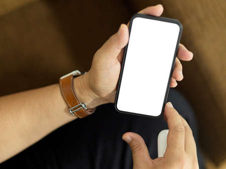 Top view of a man sitting on the couch and holding smartphone include clipping path screen