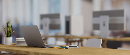 3D rendering, computer laptop on wooden table with stationery, supplies and plant pot in blurred office room background, 3D illustrationの写真素材