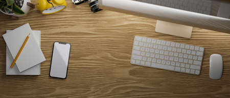 3D rendering, smartphone with mock-up screen on wooden table with computer device and stationery, 3D illustration, top viewの写真素材