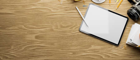 3D rendering, digital tablet with mock-up screen on wooden table with camera, supplies and copy space, 3d illustrationの写真素材