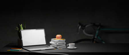 Laptop with mock-up screen on black table with stack of books, cup and stationery in home office at night, 3D rendering, 3D illustrationの写真素材