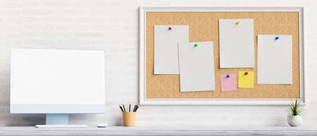 Computer device with mock-up screen on the table with stationery and notice board on the wall, 3D...