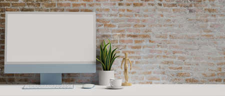 Computer with mock-up screen on white table with decorations, copy space and brick wall background, 3D rendering, 3D illustrationの写真素材