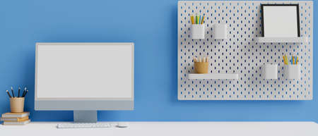 Computer with mock-up screen on white table with stationery and decoration on shelf on blue wall, 3D rendering, 3D illustrationの写真素材