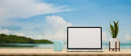 Laptop with mock-up screen, mug and plant pot on the table with river view in the background, 3D rendering, 3D illustrationの写真素材