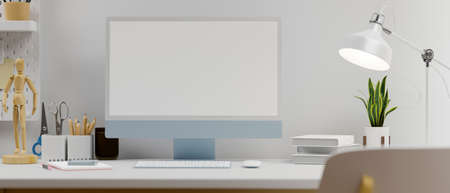 Blue pastel computer monitor with mock-up screen on table with stationery, lamp and decorations, 3D rendering, 3D illustrationの写真素材