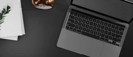 Top view of dark working desk with laptop, books and clock, 3D rendering, 3D illustrationの写真素材