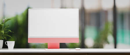 Pink pastel computer monitor with mock-up screen on white desk with garden view in the background, 3D rendering, 3D illustrationの写真素材