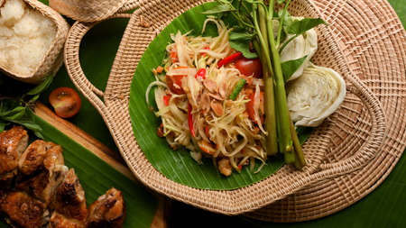 Somtum or papaya salad with grilled chicken, sticky rice and vegetables, Thai traditional foodの写真素材