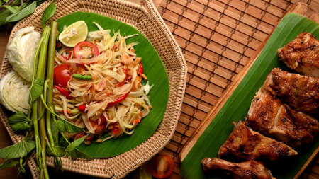 Thai food, papaya salad (Somtum) serving with Thai style grilled chicken in Thai restaurant, top viewの写真素材